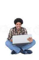 Smiling man sitting and using laptop