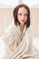 Pretty brunette sitting on bed