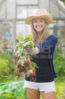Happy blonde showing home grown vegetables