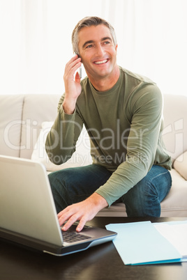 Happy man on the phone using laptop