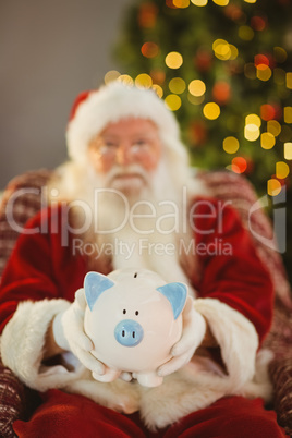 Santa claus offering piggy bank