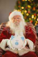 Santa claus offering piggy bank