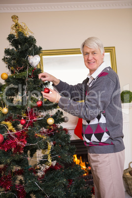 Senior man decorating the christmas tree