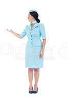 Pretty air hostess showing with hand
