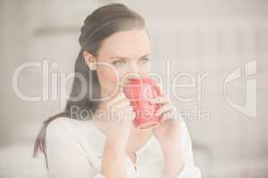 Pretty brunette drinking cup of coffee