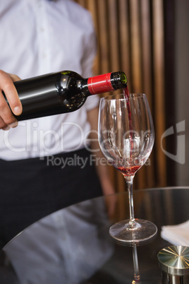 Waiter pouring a bottle of red wine