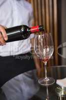 Waiter pouring a bottle of red wine