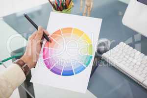 Designer working at desk using a colour wheel