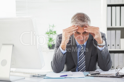 Stressed businessman with head in hands