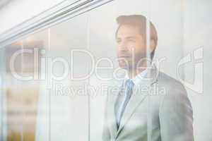 Portrait of thoughtful businessman through the window