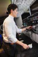 Handsome barista making a cup of coffee