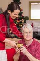 Happy mother offering gift to grandfather