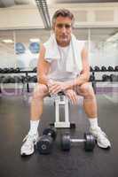 Fit man taking a break in the weights room