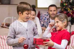 Brother and sister holding gift and baubles