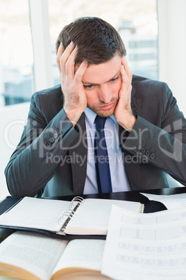 Stressed businessman with head in hands