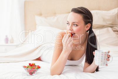 Pretty brunette having breakfast in bed