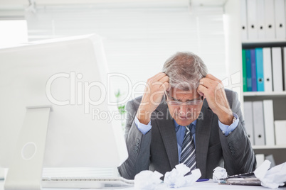 Stressed businessman with head in hands