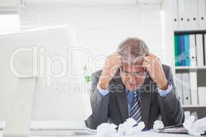 Stressed businessman with head in hands