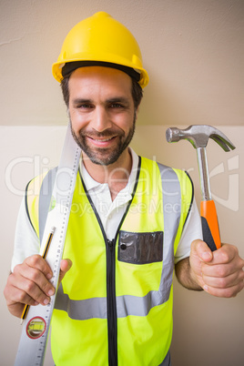 Construction worker holding spirit level and hammer