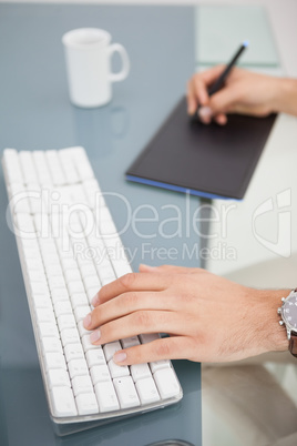 Designer using digitizer and typing on keyboard