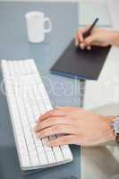 Designer using digitizer and typing on keyboard