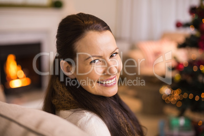 Portrait of a brunette sitting on couch at christmas