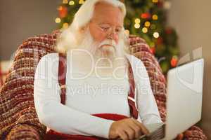Father christmas typing on laptop
