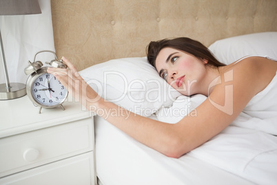 Pretty brunette turning off her alarm