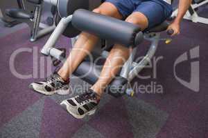 Fit man using weights machine for legs