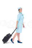 Pretty air hostess walking with suitcase