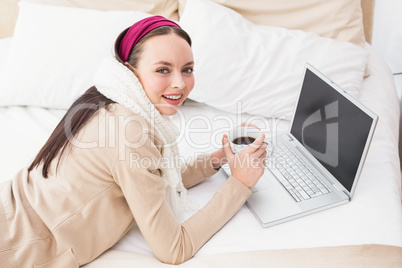 Pretty brunette using laptop on bed