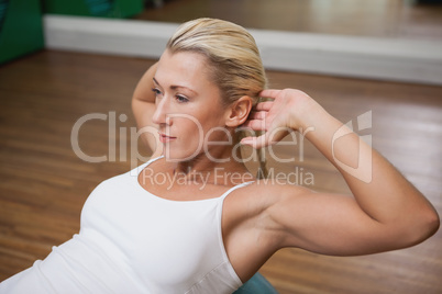 Woman doing abdominal crunches on fitness ball in gym
