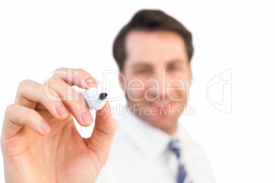 Smiling businessman writing with black marker