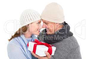 Casual couple in warm clothing holding gift