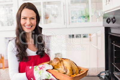 Smiling woman holding roast turkey