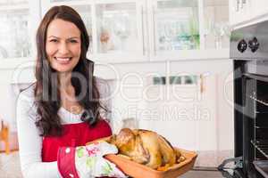 Smiling woman holding roast turkey