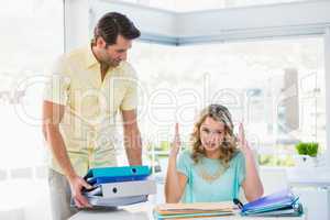 Tired creative businesswoman with stack of files on desk