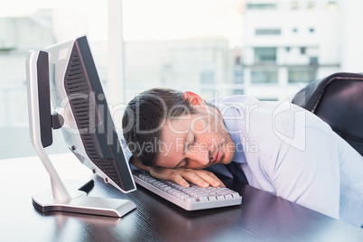 Exhausted businessman sleeping at his desk