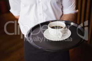 Waiter holding tray with coffee cup