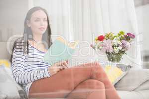 Pretty brunette reading book on couch