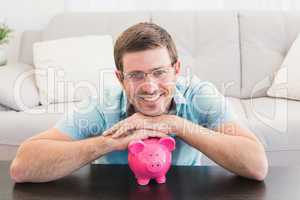 Smiling man with a piggy bank