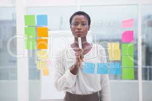 Thoughtful businesswoman holding a marker