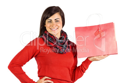 Smiling brunette showing red gift bag