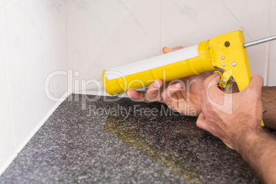 Plumber putting filling in between tiles