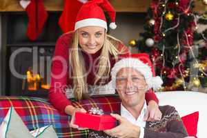 Happy woman offering husband a gift