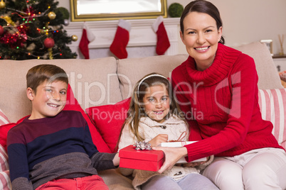 Mother offering gift to her son and daughter