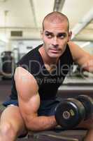 Young man exercising with dumbbell in gym