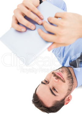 Smiling businessman lying on floor using tablet