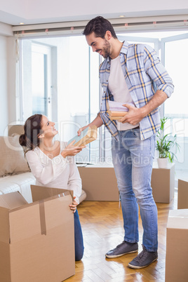 Cute couple unpacking cardboard boxes