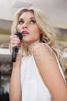 Pretty blonde woman singing while looking up
